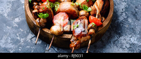 Chicken Kebab am Spieß mit Pilzen und Tomaten. Grill Fleisch auf Holzspieße Stockfoto