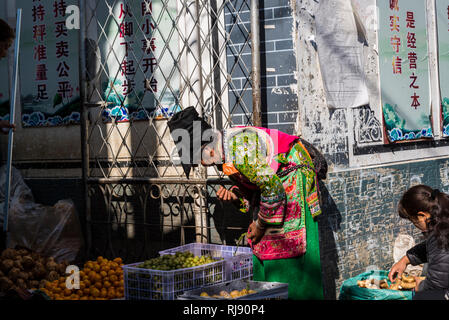 Lebensmittelmarkt, Bai Frau markt Verkäufer gekleidet in ethnischen Kostüm, Dali Altstadt, Provinz Yunnan, China Stockfoto