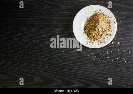 Künstlerische Fotografie der yerba mate Infusion, typische aus Argentinien, in eine weiße Platte, über einen dunklen Hintergrund Stockfoto