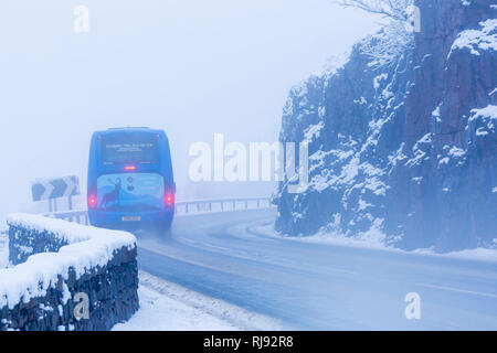 Mercedes-Benz midi-Trainer, den das Fahrzeug entlang der A82 Straße im Winter im Schnee herum an Rannoch Moor, Highlands, Schottland im Winter Stockfoto