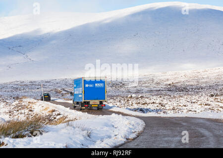 Menzies Distribution Lkw Fahrzeug entlang der A82 Straße am Tag der Winter mit Schnee um an Rannoch Moor, Highlands, Schottland im Winter Stockfoto