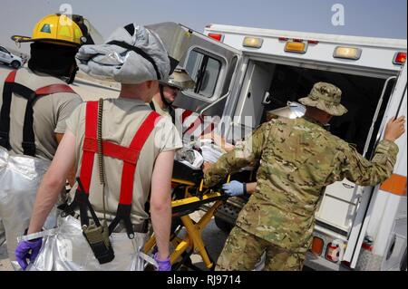 379 Expeditionary medizinische Gruppe Flieger Last eine simulierte Opfer in einen Krankenwagen während einer Antiterrorism Training übung im Al Udeid Air Base, Katar, Nov. 3, 2016. Der Zweck der Übung war, dass Verfahren vorhanden sind, um die Sicherheit der Basis sicherstellen, dass das Personal zu testen. Stockfoto