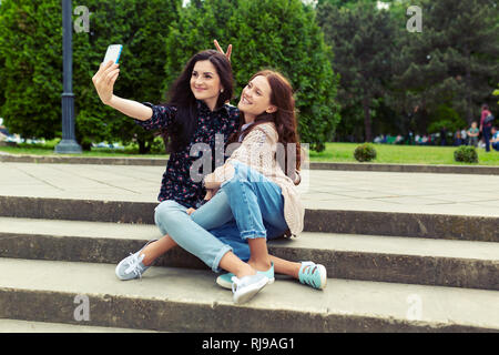 Nettes hübsches Mädchen lustig selfie auf der Straße, sich gemeinsam amüsiert, Freude, Glück, Liebe, Freundschaft, Schwestern. Stockfoto