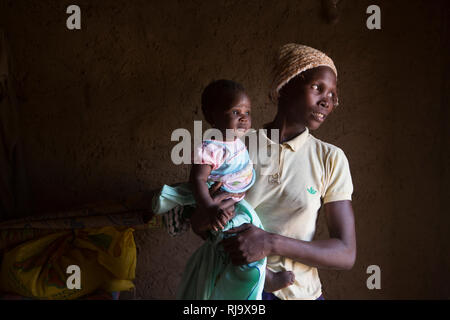 Yarsi Village, Yako, 1. Dezember 2016; Leontine Ouedraogo, Mitglied der Village Tree Enterprise Shea Group mit ihrem 5 Monate alten Baby Saminatou Dem. Stockfoto