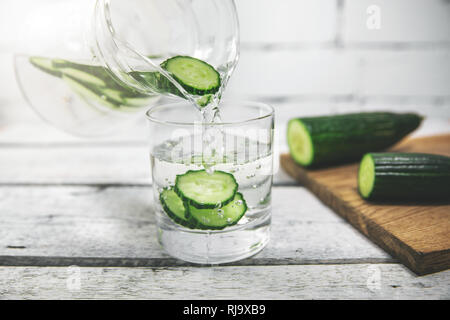 Detox drink - frische Gurke Wasser in ein Glas gießen Stockfoto