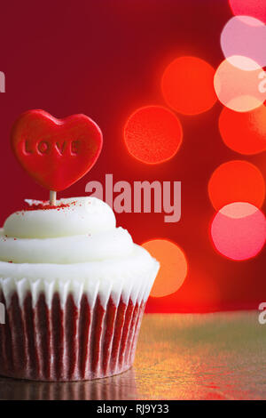 Herz in der Cupcake auf die Liebe abstract defokussierten Valentines Tag roter Hintergrund Stockfoto
