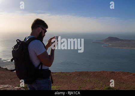 Der Mann Fotografien auf einer Insel im Ozean, stehen am Rand einer Klippe. Mirador del Rio, Lanzarote, Spanien. Stockfoto