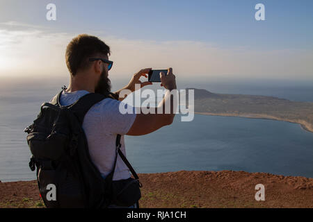 Der Mann Fotografien auf einer Insel im Ozean, stehen am Rand einer Klippe. Mirador del Rio, Lanzarote, Spanien. Stockfoto