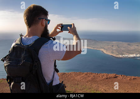 Der Mann Fotografien auf einer Insel im Ozean, stehen am Rand einer Klippe. Mirador del Rio, Lanzarote, Spanien. Stockfoto