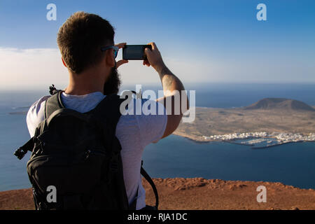 Der Mann Fotografien auf einer Insel im Ozean, stehen am Rand einer Klippe. Mirador del Rio, Lanzarote, Spanien. Stockfoto