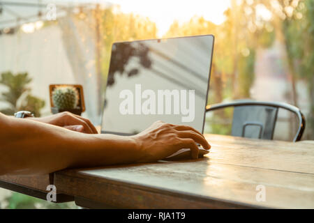 Mann mit Computer Maus arbeiten mit Laptop am Tisch am Morgen. Stockfoto