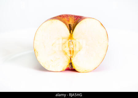 Die Hälfte rot Apfel Obst auf dem Teller auf weißem Hintergrund Stockfoto