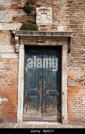 Verwitterten hölzernen Tür in Backstein Fassade in Venedig Stockfoto