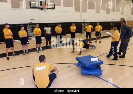JACKSONVILLE, Fla. (Nov. 1, 2016) Petty Officer 3rd Class Rakim Rowley, Assistant Befehl fitness Leader bei Naval Station Mayport zeigt einen richtigen Push up für Segler, die von der Basis Sicherheit vor Ihrer physischen Bereitschaftstest Stockfoto