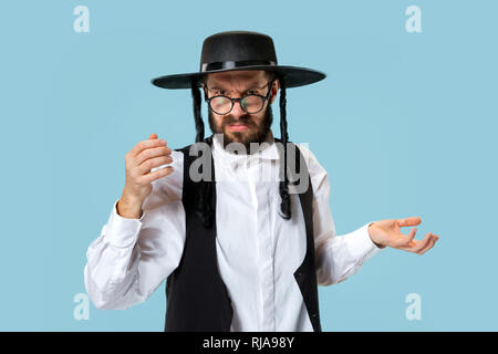 Portrait einer jungen orthodoxen Hasdim jüdischen Mann an Jüdische Festival der Purim im Studio. Die purim, jüdische, Festival, Urlaub, Feier, Judentum, Gebäck, Tradition, Cookie, Religion Konzept. Stockfoto