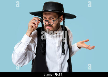 Portrait einer jungen orthodoxen Hasdim jüdischen Mann an Jüdische Festival der Purim im Studio. Die purim, jüdische, Festival, Urlaub, Feier, Judentum, Gebäck, Tradition, Cookie, Religion Konzept. Stockfoto