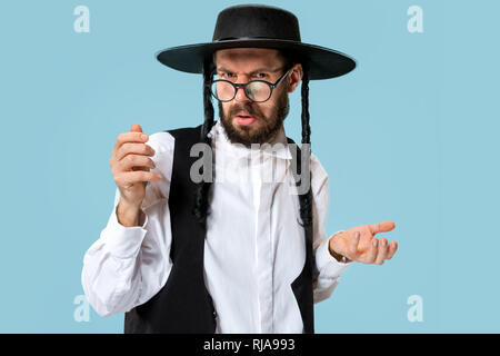 Portrait einer jungen orthodoxen Hasdim jüdischen Mann an Jüdische Festival der Purim im Studio. Die purim, jüdische, Festival, Urlaub, Feier, Judentum, Gebäck, Tradition, Cookie, Religion Konzept. Stockfoto