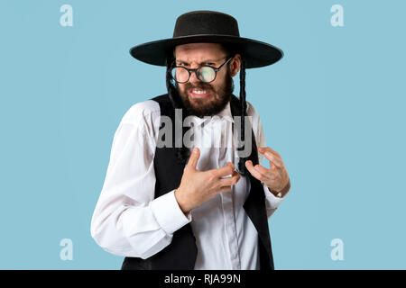 Portrait einer jungen orthodoxen Hasdim jüdischen Mann an Jüdische Festival der Purim im Studio. Die purim, jüdische, Festival, Urlaub, Feier, Judentum, Gebäck, Tradition, Cookie, Religion Konzept. Stockfoto