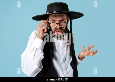 Portrait einer jungen orthodoxen Hasdim jüdischen Mann an Jüdische Festival der Purim im Studio. Die purim, jüdische, Festival, Urlaub, Feier, Judentum, Gebäck, Tradition, Cookie, Religion Konzept. Stockfoto