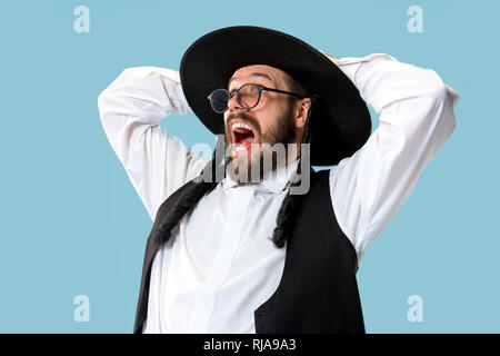 Portrait einer jungen orthodoxen Hasdim jüdischen Mann an Jüdische Festival der Purim im Studio. Die purim, jüdische, Festival, Urlaub, Feier, Judentum, Gebäck, Tradition, Cookie, Religion Konzept. Stockfoto