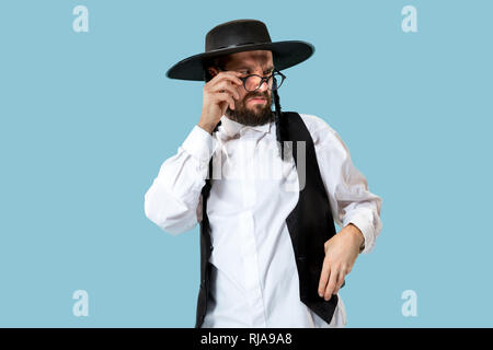 Portrait einer jungen orthodoxen Hasdim jüdischen Mann an Jüdische Festival der Purim im Studio. Die purim, jüdische, Festival, Urlaub, Feier, Judentum, Gebäck, Tradition, Cookie, Religion Konzept. Stockfoto