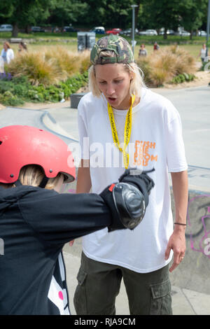 Professionelle female Skater, Lucy Adams, lehre Mädchen, wie auf der Ebene Skatepark in Brighton, East Sussex, England zu skaten. Stockfoto