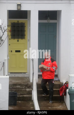 Ein Royal Mail Postbote liefert Post und Pakete an Wohnimmobilien. Bild von James Boardman Stockfoto