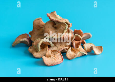 Getrocknete äpfel Slice in einem Haufen auf blauem Hintergrund, Zutaten für türkische Apfeltee, Hautnah. Hausgemachte sonnengetrockneten Bio Apfelscheiben. Stockfoto