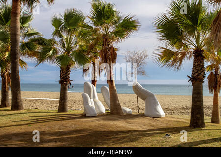 Los Boliches, Spanien. Die Open-Hand-Skulptur von Charo Garcia, die 2015 errichtet und in einen Palmenhain am Strand von Los Boliches, Spanien eingebettet wurde. Stockfoto