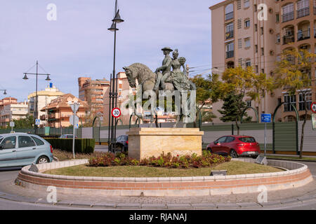 Fuengirola, Spanien. Eine Bronzestatue eines Paares auf einem Pferd, sie reitet Seitensattel auf einem Kreisverkehr in Fuengirola, Spanien. Stockfoto