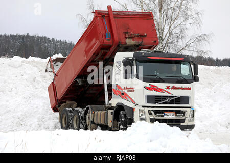 Salo, Finnland - Februar 2, 2019: Volvo Kipper entlädt Schnee von den Straßen und Parkplätze an den kommunalen Schnee dumping Bereich geräumt. Stockfoto