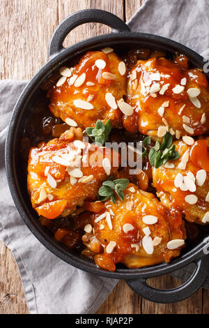 Hähnchen Schenkel in Apricot Glaze mit Mandeln close-up in der Pfanne. Vertikal oben Ansicht von oben Stockfoto