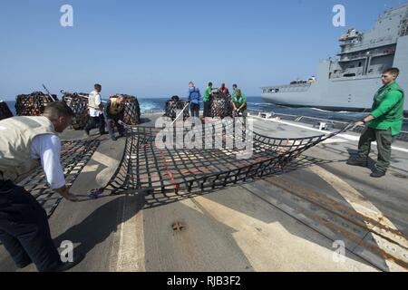 Roten Meer (Nov. 6, 2016) Segler verbreiten einen Cargo Net auf dem Flugdeck der geführten Anti-raketen-Zerstörer USS Roosevelt (DDG80) während einer Auffüllung-auf-See mit dem Dry Cargo und Munition ship USNS Cesar Chavez (T-AKE 14). Roosevelt, eingesetzt als Teil der Eisenhower Carrier Strike Group, unterstützt Maritime Security Operations und Theater Sicherheit Zusammenarbeit in den USA 5 Flotte Bereich der Operationen. Stockfoto