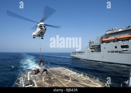Roten Meer (Nov. 6, 2016) ein Hubschrauber, der für die Trockenschiffahrt und Munition ship USNS Cesar Chavez (T-AKE 14) trägt die Versorgung der Flight Deck der geführten Anti-raketen-Zerstörer USS Roosevelt (DDG80) während einer Auffüllung-auf-See. Roosevelt, eingesetzt als Teil der Eisenhower Carrier Strike Group, unterstützt Maritime Security Operations und Theater Sicherheit Zusammenarbeit in den USA 5 Flotte Bereich der Operationen. Stockfoto