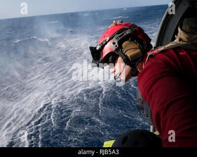 Us Air Force Staff Sgt. Adam Lopez, 31 Rescue Squadron pararescueman, scannt das Meer bei einem ein HH-60G Pave Hawk Hubschrauber bis zum 33 RQS Nov. 4, 2016 zugeordnet, vor der Küste von Okinawa, Japan. Während der Ausbildung, Mitglieder des 33 RQS praktizierten Verwertungsverfahren für eine simulierte Abgestürzten Piloten in einer feindlichen Umgebung. Stockfoto