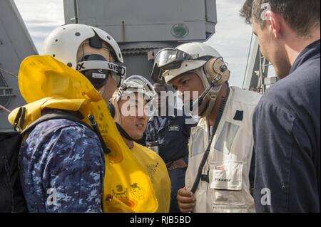 Pazifik (Nov. 6, 2016) Cmdr. Gervy Alota, kommandierender Offizier der Amphibischen dock Landung Schiff USS Comstock (LSD 45) grüsst Lt. j.g. Shogo Kudo, Links, und Petty Officer 2nd class Kazuhiko Iwanatsu, Mitte, wie sie Comstock für scharfe Schwert 17 begeben. Scharfes Schwert 17 ist ein gemeinsames und bilateralen Bereich Training (Ftx) zwischen US-amerikanischen und japanischen Truppen bedeutete die Bereitschaft und die Interoperabilität im Rahmen des U.S.-Japan Alliance zu erhöhen. Stockfoto