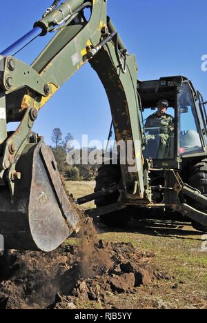 FORT HUNTER LIGGETT, Ca. (Nov. 3, 2016) - Petty Officer 1st Class Ryan Hell mit Naval Mobile Konstruktion Bataillon 18 (NMCB 18) verwendet ein CAT 420 Tieflöffel defensive Kämpfe Gruben zu graben, während ein Feld Training übung (Ftx). NMCB 18 ist die Teilnahme an diesem FTX Bereitstellungsbereitschaft zu erhalten. Stockfoto