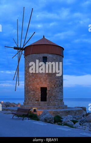 Windmühlen, Insel Rhodos. Blick auf die historische Windmühlen in den Mandraki Hafen, in der Dämmerung. Stockfoto