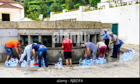 Menschen sammeln der berühmten Agua de Luso Luso (Mineralwasser) aus der kostenlosen Lieferung Brunnen des Hl. Johannes im Zentrum der Stadt Esposende, Portugal Stockfoto