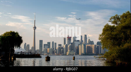 Blick auf Flugzeug durch die Toronto Skyline mit dem CN Tower fliegen, vom Toronto Islands. Toronto, Ontario. Stockfoto