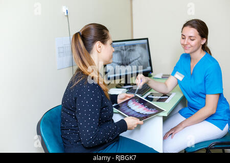 Junge Frau Zahnärzte und Patientin besprechen der Röntgenaufnahme auf dem Computer Behandlung Diskussion Nahaufnahme Stockfoto