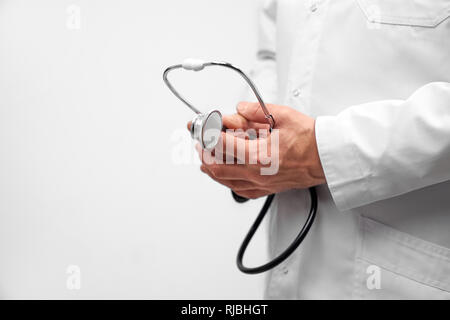 Stethoskop hautnah. Therapeut Holding in den Händen Ausrüstung für die Prüfung und Diagnose von Krankheiten der Völker. Hno-Arzt in Weiß medizinische Fell posieren. Stockfoto