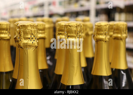 Champagner Flaschen in einer Reihe, selektiven Fokus. Sekt Produktionskonzept, Liquor Store Stockfoto