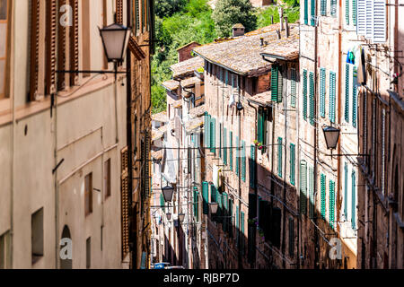 Siena, Italien schmale Gasse Straße in der historischen, mittelalterlichen Altstadt Dorf in der Toskana mit niemand im Sommer Tag und Architektur Wänden mit Fenstern hi Stockfoto