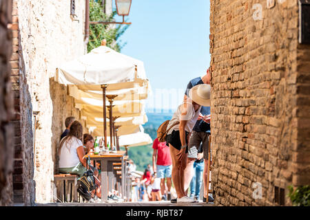San Gimignano, Italien - 27 August, 2018: die Menschen sitzen, Wein trinken und Essen im Cafe Restaurant Weinprobe in kleinen mittelalterlichen Stadt Dorf in Tusc Stockfoto