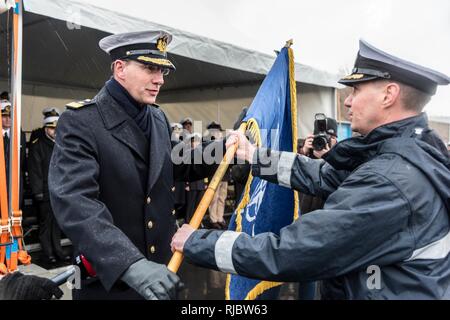 Zeebrugge, Belgien (Jan. 15, 2018) der NATO Allied Maritime Command stellvertretender Stabschef für Operationen, Konteradmiral Jens Nemeyer, präsentiert die NATO Flagge für den eingehenden Kommandant der Standing NATO Mine Gegenmaßnahmen Gruppe, Belgischen Marine Commander Peter Ramboer im Rahmen des Festakts zur Änderung der Befehl in Zeebrugge Marine Base, in Belgien. Stockfoto