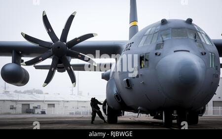 Ein 153 Airlift Wing Betreuer Orte Bremsklötze an den Rädern einer C-130 H nach der Ankunft in Eglin Air Force Base, Fla., Jan. 11. Luftwaffe erste voll aufgerüstet C-130H ist hier für Test und Evaluierung auf die neue modifizierte Propeller und Motoren. Stockfoto