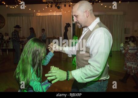 Service für Mitglieder und ihre Töchter nehmen an der Stiefel'n Belles Daddy-Daughter Dance an Marine Corps Air Station Iwakuni, Japan, Jan. 13, 2018. Väter und Töchter tanzten, machte Bilder, Spiele gespielt und gewonnen Gewinnspiel Wettbewerbe, wie sie die Nacht gemeinsam erstellt und Erinnerungen zusammen. Stockfoto