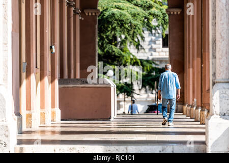 Perugia, Italien - 29 August, 2018: Der Mann, der zu Fuß durch die Regierung Büro Eingang Gebäude in der Stadt Dorf im Sommer Region Umbrien Stockfoto