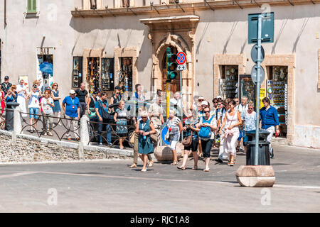 Assisi, Italien - 29 August 2018: Viele Touristen Tour Gruppe zu Fuß auf der Straße in Umbrien Stadt Stadt Dorf an den populären berühmten Attraktion überfüllt Stockfoto